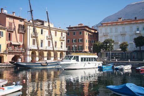 Havnen i Malcesine Den hyggelige, kvadratiske miniaturehavn i Malcesine omgivet af farverige restauranter og cafeer