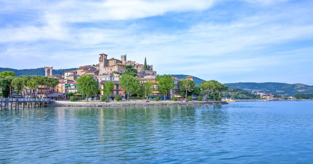Passignano ved Trasimenersøen Udsigt over Trasimenersøens rolige perlemorsspejl med Passignanos tage i forgrunden