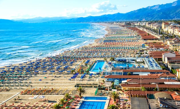 Lange, snorlige rækker af farverige parasoller på den brede sandstrand i Viareggio